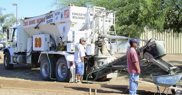 Home Depot branded concrete truck pouring concrete into forms