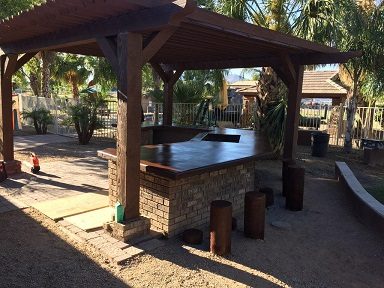 Outdoor concrete bar and patio under a wooden pergola