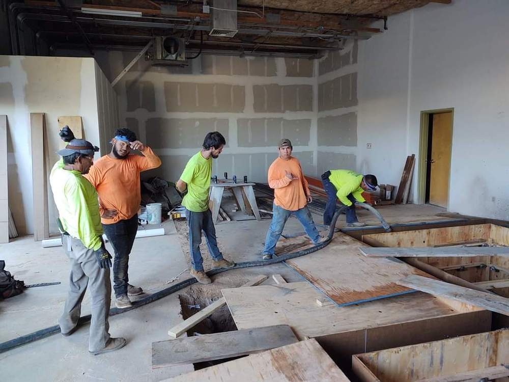 Crew pumping concrete inside a commercial building